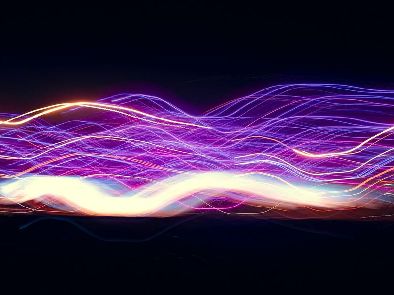Abstract image representing airflow and energy with blue lines on a dark background.